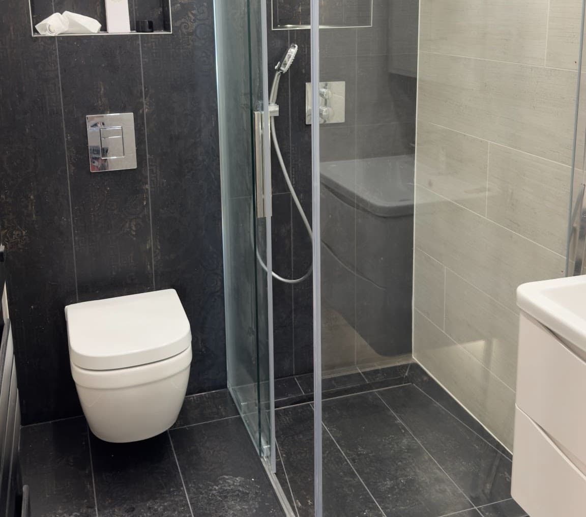 Renovated bathroom with walk-in rain shower and illuminated mirror cabinet